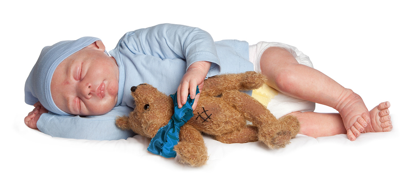 Reborn baby boy doll sleeping with a bear in his hand